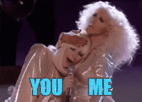 Celebrity gif. Christina Aguilera pulls Lady Gaga's head to her chest as she sings into a microphone. Text, "You. Me."