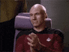TV gif. Patrick Stewart as Picard in Star Trek sits in his chair, nods and gives a slow clap and a discerning glance.