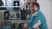 SNL gif. Bobby Moynihan stands in front of a Star Wars toy display case. He turns towards us excitedly and pops up a big thumbs up, smiles and says “awesome!”