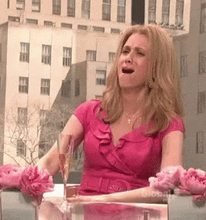 SNL gif. Kristin Wiig plays a co-host of the View. She sits at the view table with a glass of champagne in front of her. She cringes and waves her hand in front of her face. She points to the person next to her and then pinches her nose.