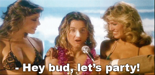 Movie gif. Sean Penn as Jeff Spicoli in Fast Times At Ridgemont High has sunblock on his nose and a lei around his neck while he holds a surfing trophy in his hands. Two beautiful women in bikinis stand next to him. A man holds a mic out to Jeff and he says, “Hey bud, let’s party!”