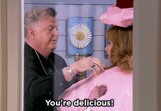 TV gif. We see Robert Michael Morris as Mickey on The Comeback through a window leaning in toward a woman and cooing to her as he stands back with a manic smile. Text, "You're delicious!"