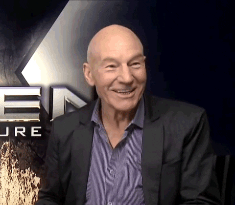 Celebrity gif. In front of an X-Men poster, Patrick Stewart wears a black blazer and a striped blue shirt. He speaks to us cheerfully: Text, "Damn that's good."