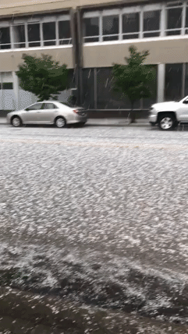 People Shelter at Bus Stop as Hail Pounds Minneapolis Street