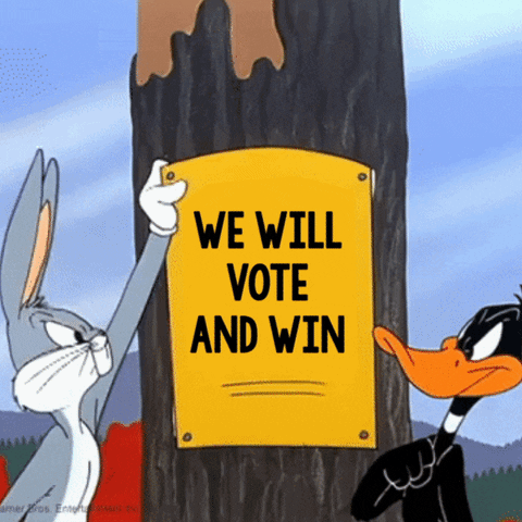 Looney Tunes gif. Daffy Duck and Bugs Bunny stand off in front of a tree with a sign pinned to it. An angry Bugs Bunny rips down a sign that reads, “We will vote and win,” revealing a sign beneath that says, “They will lose and lie.” Daffy Duck glares, ripping down the sign and revealing the sign that says, “We will vote and win.”