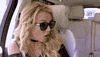 Celebrity gif. Britney Spears's hands cover her dropped jaw as if in shock as she sits near someone in a car. 