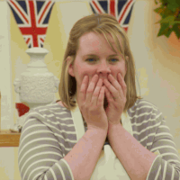 TV gif. A young female contestant from The Great British Baking Show covers her mouth in shock.