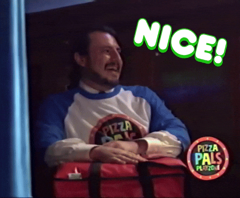 Video gif. A man has a big smile on his face gives two thumbs up. He has a big red pizza carrier on his lap. Text, “Nice!”