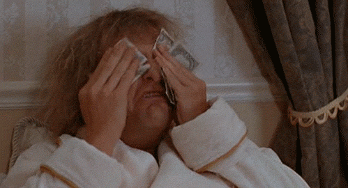 Movie gif. Jeff Daniels as Harry in Dumb and Dumber. He is sobbing in a hotel bed with a robe on and he wipes his tears with dollar bills.