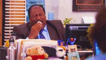 The Office gif. Leslie David Baker as Stanley laughs hysterically at his desk and dabs tears from his face with a tissue.