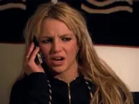 Celebrity gif. Britney Spears holds a cell phone up to her ear. She has a concerned look on her face as she listens to the other person on the phone. She then goes, “ohhh,