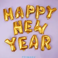 Stop motion gif. Pastel confetti rains down on gold mylar balloons that spell out, 