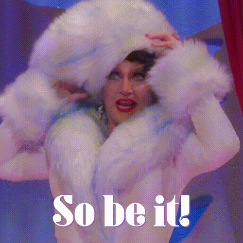 Video gif. Wearing a white fur coat and a big white fur hat, Jinkx Monsoon stands up, slaps their hat, and smiles as they speak to offscreen. Text, "So be it!"