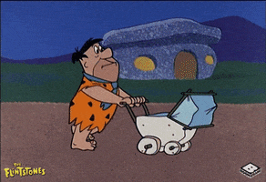 Flintstones gif. Fred pushes a baby stroller while running super fast past houses down a road.