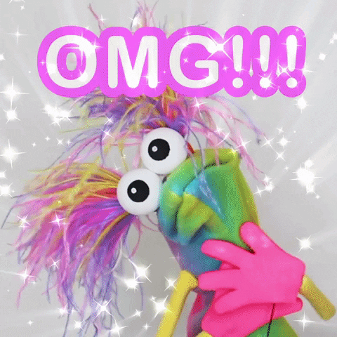 Digital art gif. A tie dyed sock puppet with arms and pink hands and two colorful ponytails sprouting from its head. We zoom on its googly eyed face as it gasps. Sparkles fill the air in amazement. Text, “OMG!!!”