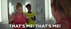 Movie gif. Amy Schumer as Renee in I Feel Pretty, looking at her self in the mirror in disbelief and pointing at herself while saying, "that's me! That's me!" which appears as text. Sasheer Zamata as Tasha stands behind her, nodding and smiling.