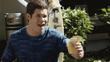 TV gif. From Comedy Central Stand-Up, a group of four friends at a backyard party raise their glasses to cheers and then lean in to each other to hug.