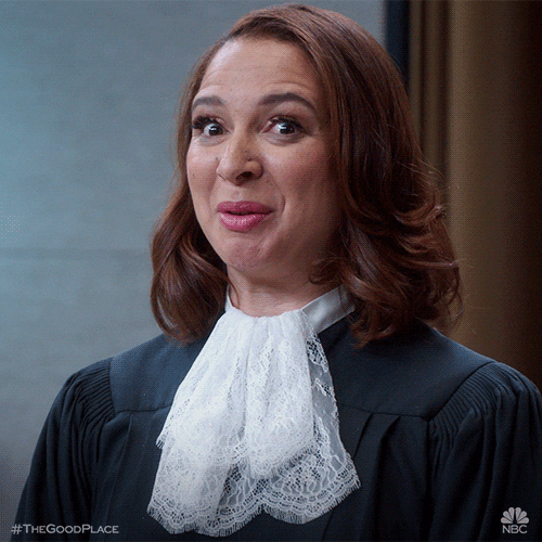 TV gif. Maya Rudolph as Judge Gen in The Good Place gives us a broad, knowing smile with a wink, and a finger gun.