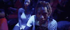 Music video gif. Fetty Wap in his music video My Way. He's wearing driving gloves and rapping in the back of a car filled with people.