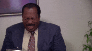 The Office gif. Leslie David Baker as Stanley closes his eyes as he buckles over in uncontrollable laughter.