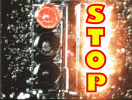 Digital art gif. An unchanging stoplight. The word "STOP" outlined in flames superimposed on top.