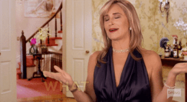 Reality TV gif. Sonja Morgan from the Real Housewives of New York City rolls her eyes, flips both of her hands, and emphatically says, "Whatever."