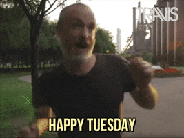 Celebrity gif. Fran Healy hops up and down happily, dancing with chicken wing arms. Text, "Happy Tuesday."