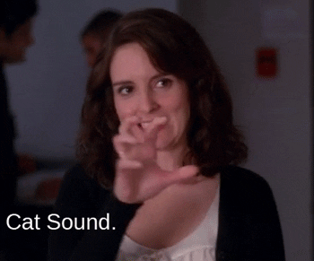 GIF of Tina Fey making a claw out of her hands and saying "cat sound".