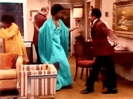 TV gif. Isabel Sanford as Louise and Sherman Hemsley as George in The Jefferson. The two are dressed in formal wear and begin dancing with one another and bumping booties as they jive to the music.