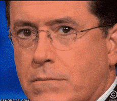 Celebrity gif. Close up of Stephen Colbert's face as he stares at us. Slowly the smile on his face grows wider and then he says, “K.”