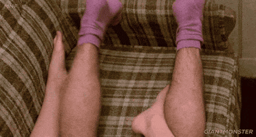 Movie gif. From Fast Times at Ridgemont High, Robert Romanus as Mike and Jennifer Jason Leigh as Stacy are having sex on a couch, but all we see is Stacy's bare feet and Mike's legs and pink socks.
