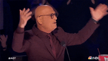 TV gif. Howie Mandel from America's Got Talent extends his arms in awe and says "amazing."