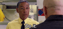TV gif. Wearing a pastel yellow shirt with a dark blue tie, Giancarlo Esposito as Gus from Breaking Bad manages to look both friendly and menacing while giving orders to an employee in the foreground. Text, "Do it."